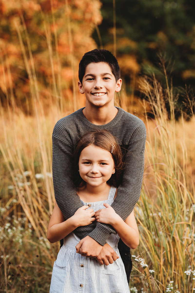 grand rapids michigan family photography session outdoors with a brother and sister hugging