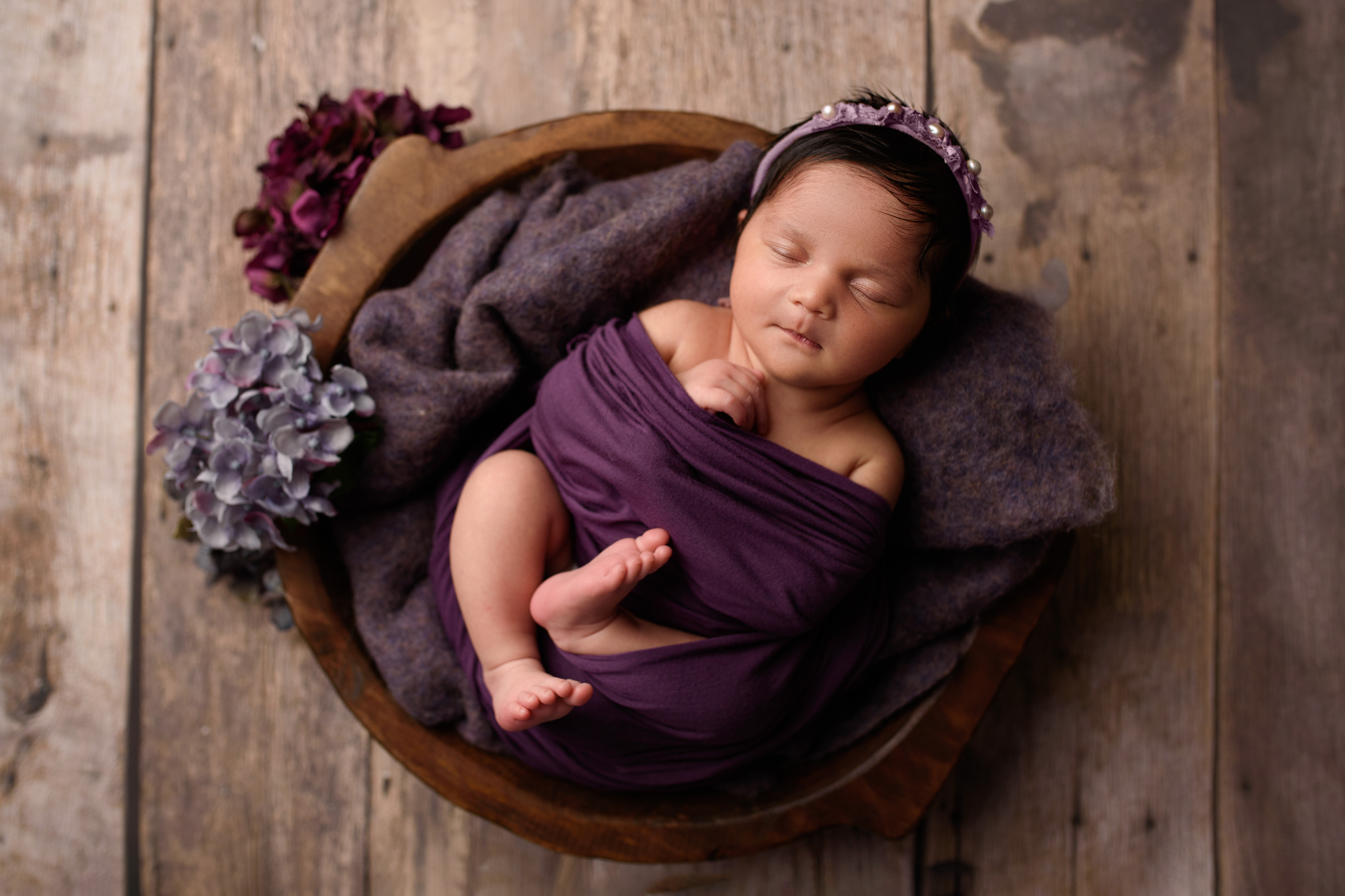 grand rapids newborn photographer baby girl in purple wrap in a brown bowl