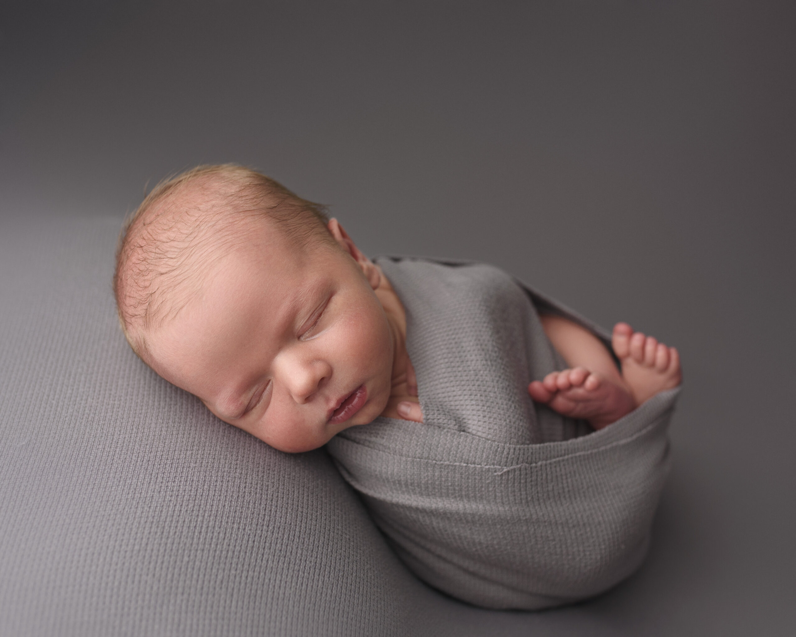 grand rapids michigan newborn photographer session baby boy on grey
