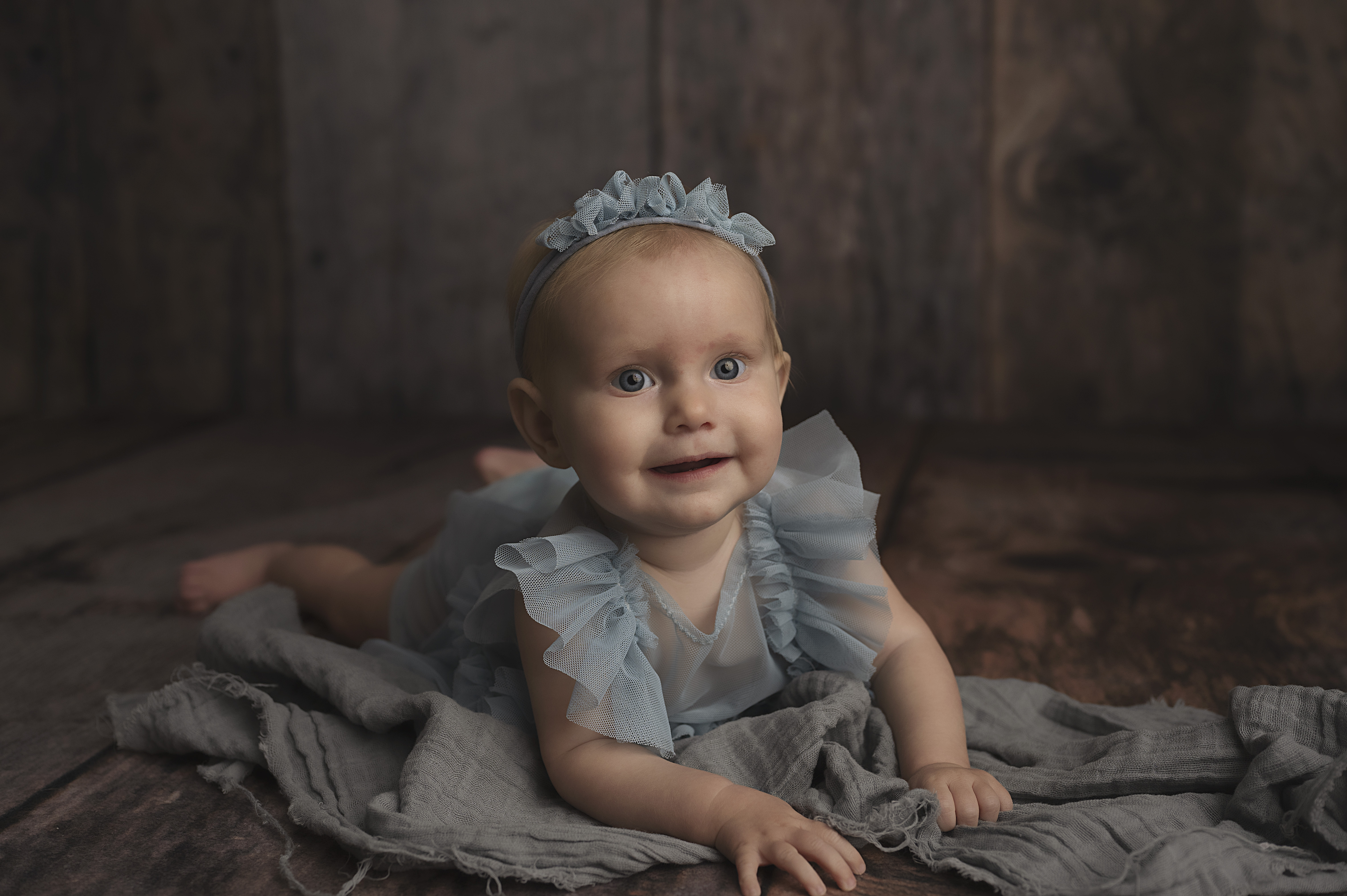 grand rapids baby photographer sitter session girl in blue dress tummy time