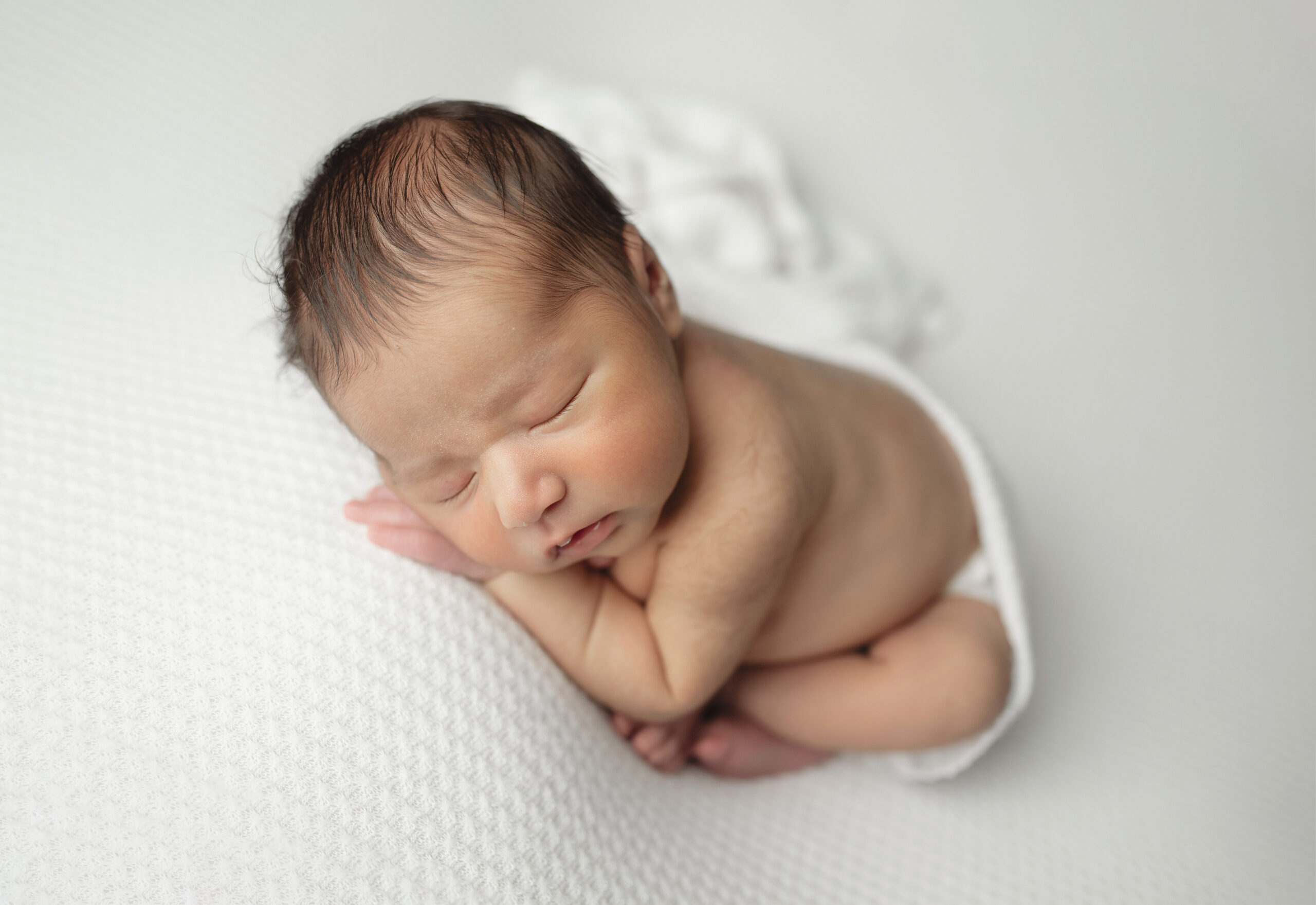 Grand rapids newborn photographer baby sleeping on white blanket