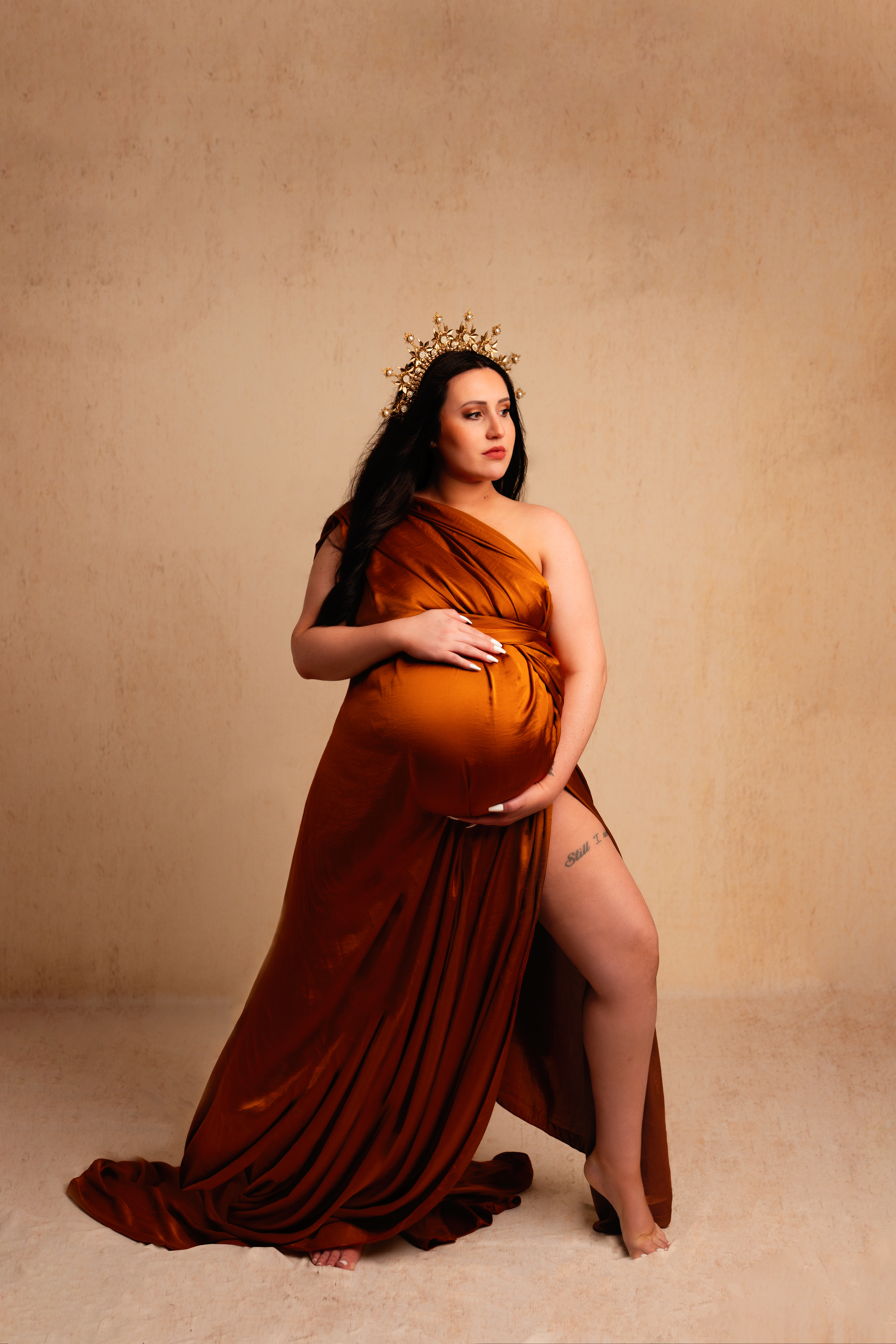 Grand rapids maternity photo shoot mother wearing gold wrap with gold crown