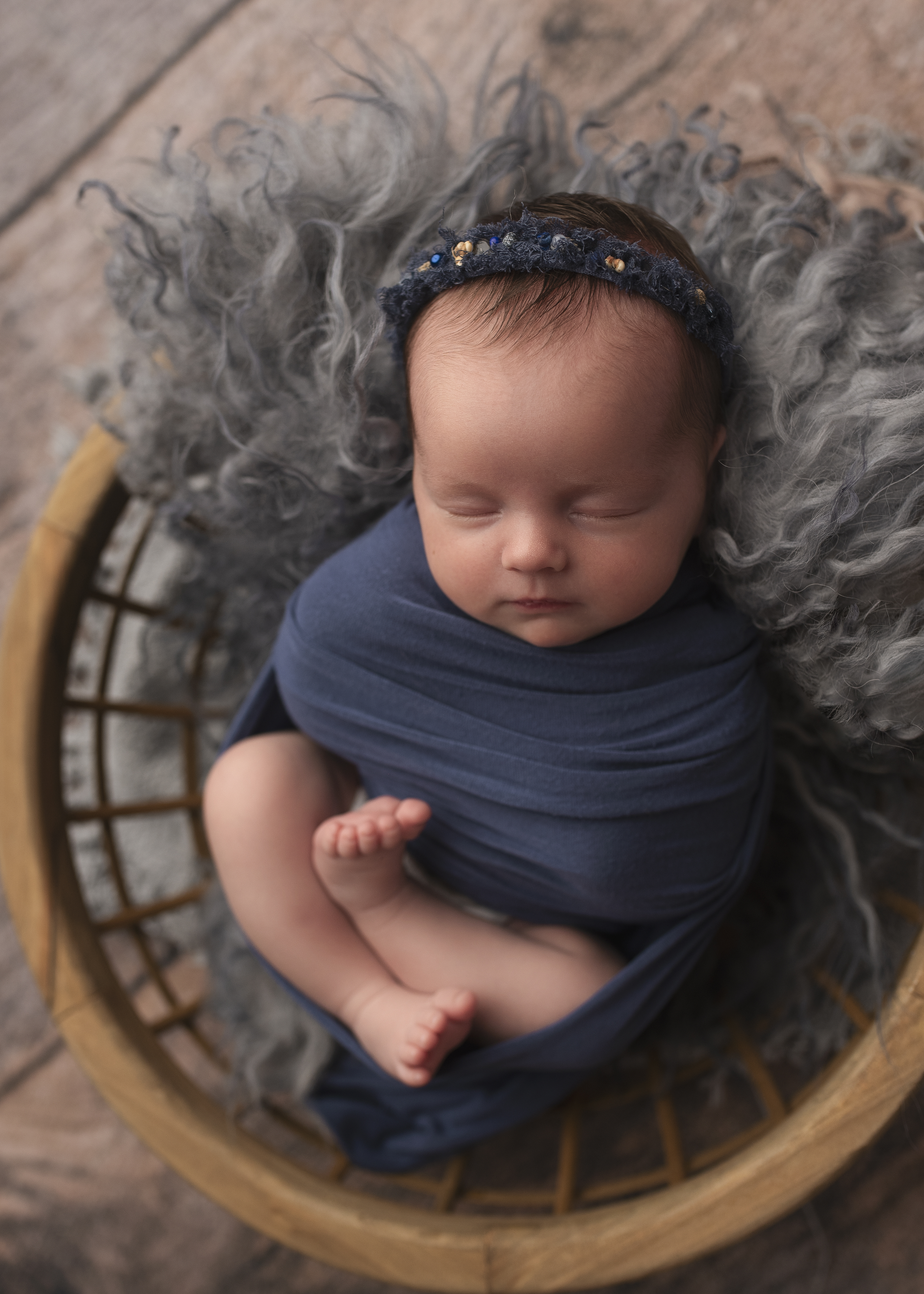 grand rapids newborn photo session baby sleeping wrapped in blue swaddle