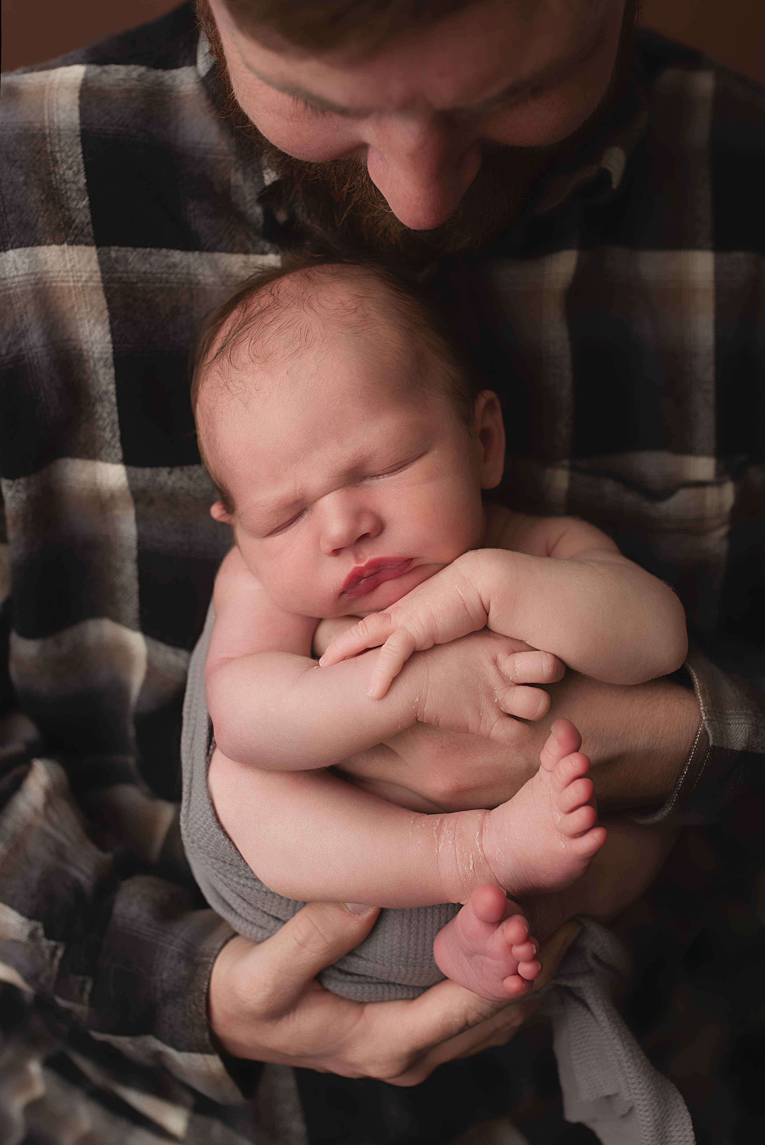Newborn baby boy sleeping in fathers arms