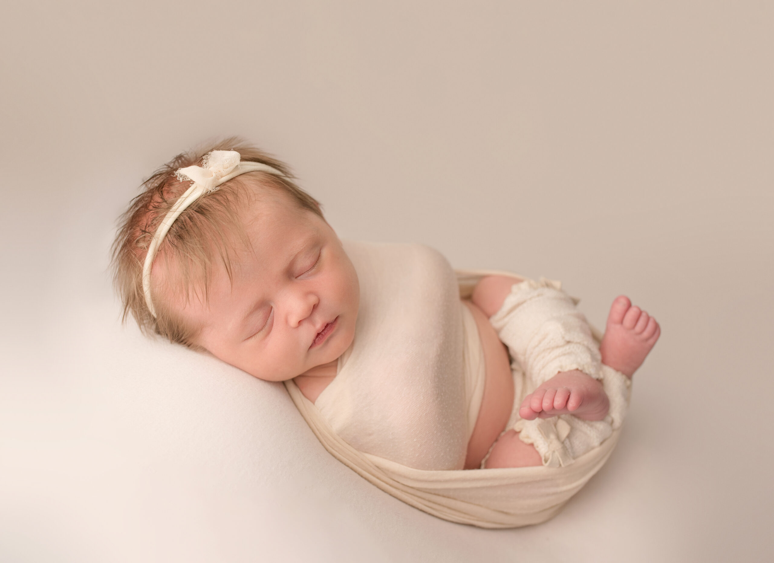 newborn photo session sleeping baby sleeping on cream blanket