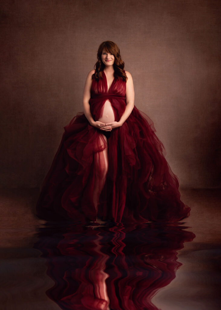 Maternity Photography, woman in long red dress against a brown background